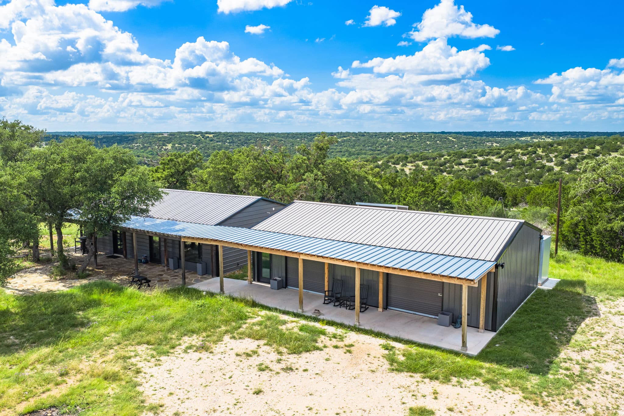 Aerial view of a ranch property protected by a light gray metal roof
